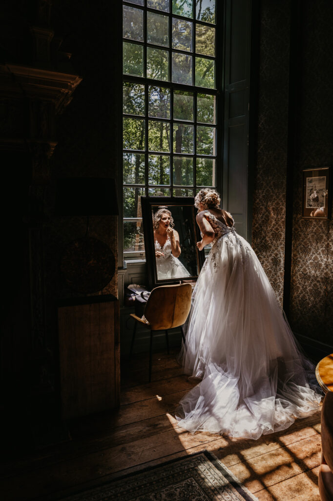 bruid maakt zich op voor spiegel kasteel Weijenburg